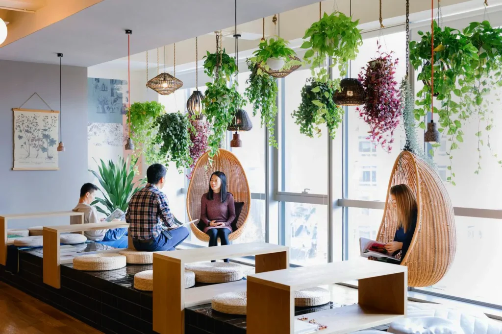 Estantes e paredes verdes, enfatizando uso de plantas pendentes como jiboia ou Scindapsus.